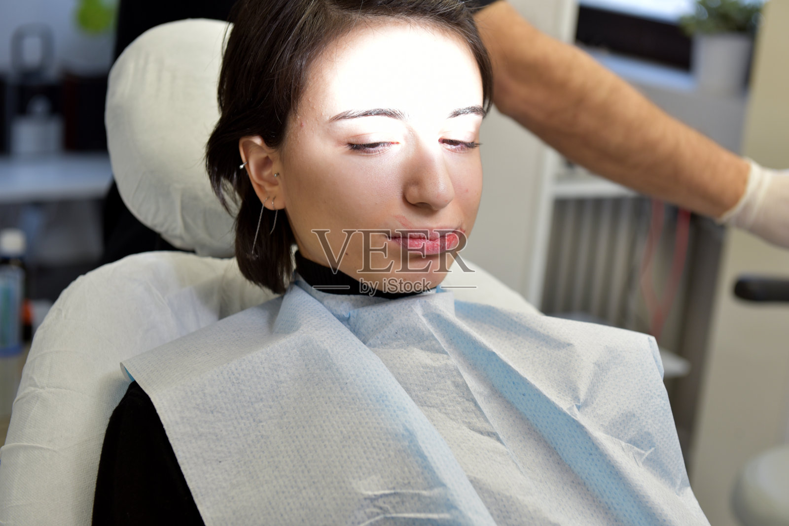 在牙科诊所接受牙科治疗的年轻女人照片摄影图片