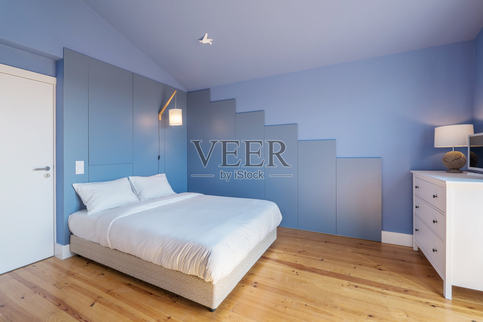 现代公寓室内设计以蓝色为主色调，小而舒适的卧室照片摄影图片