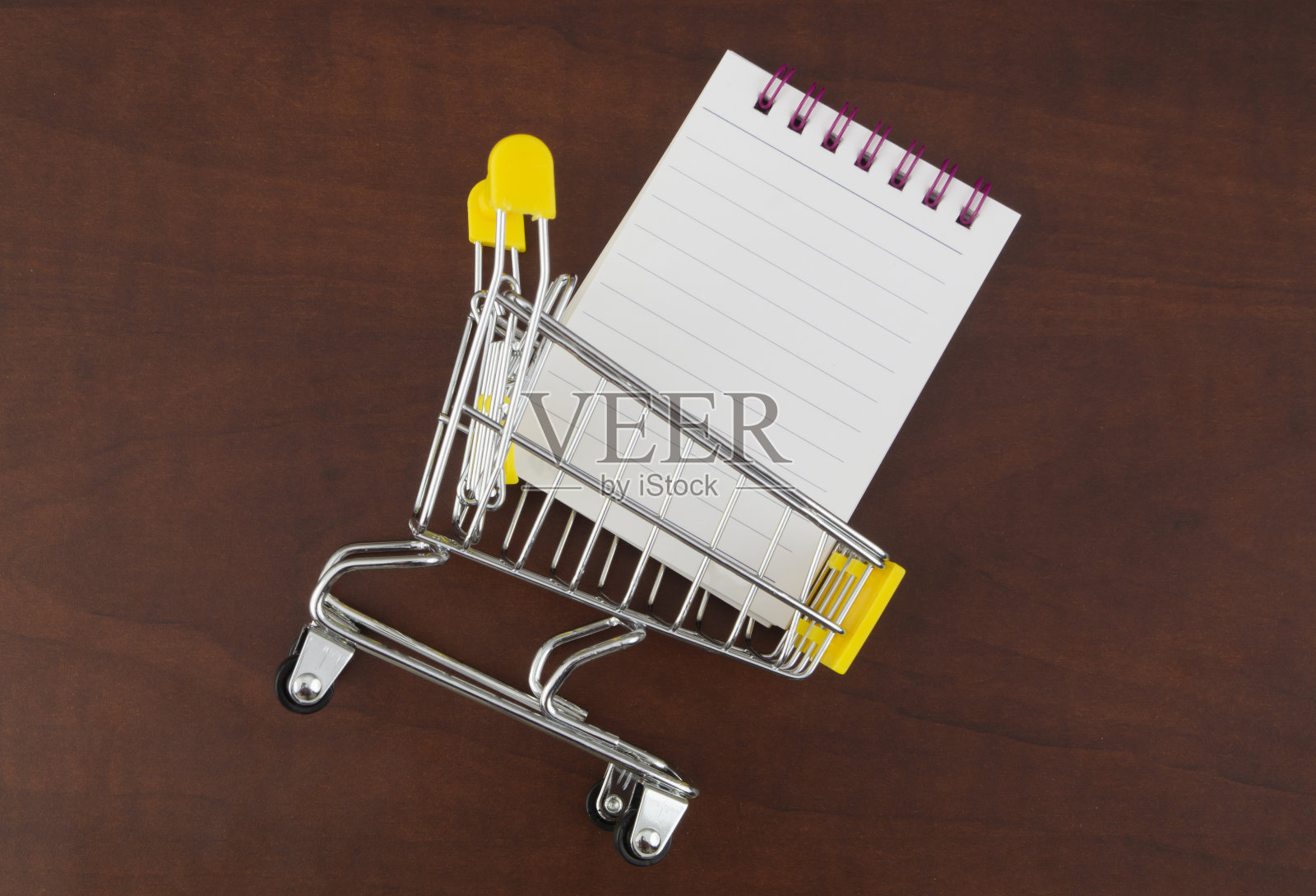 黄色购物车和空白记事本页面照片摄影图片
