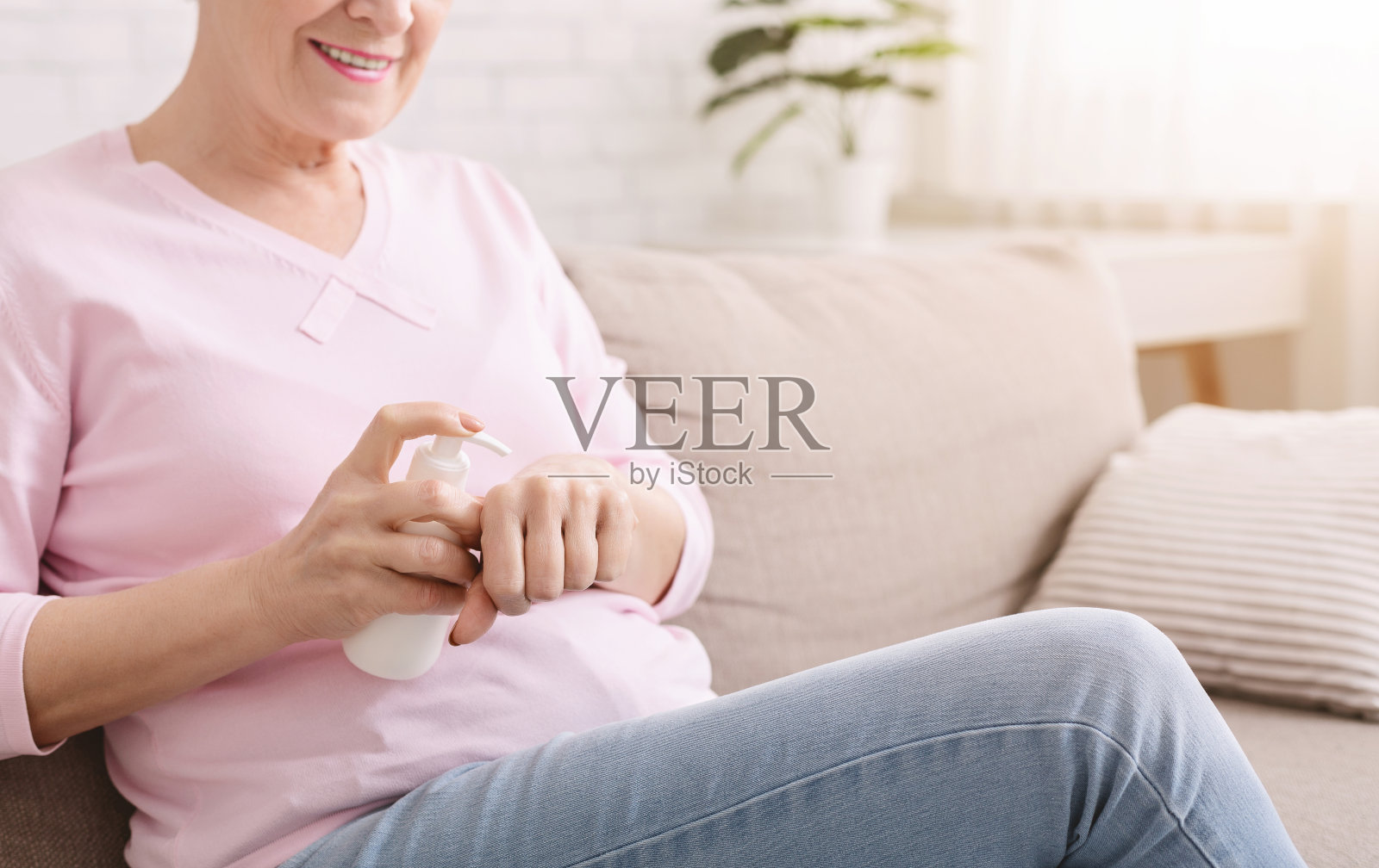 老年女士在手上涂抹保湿霜照片摄影图片