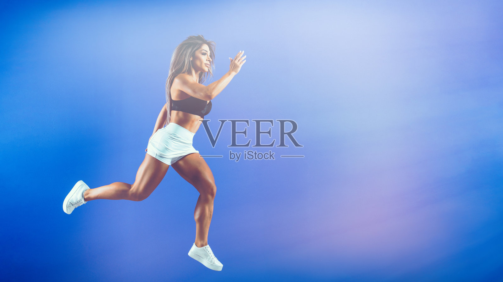 在空中跳跃的健美女性照片摄影图片