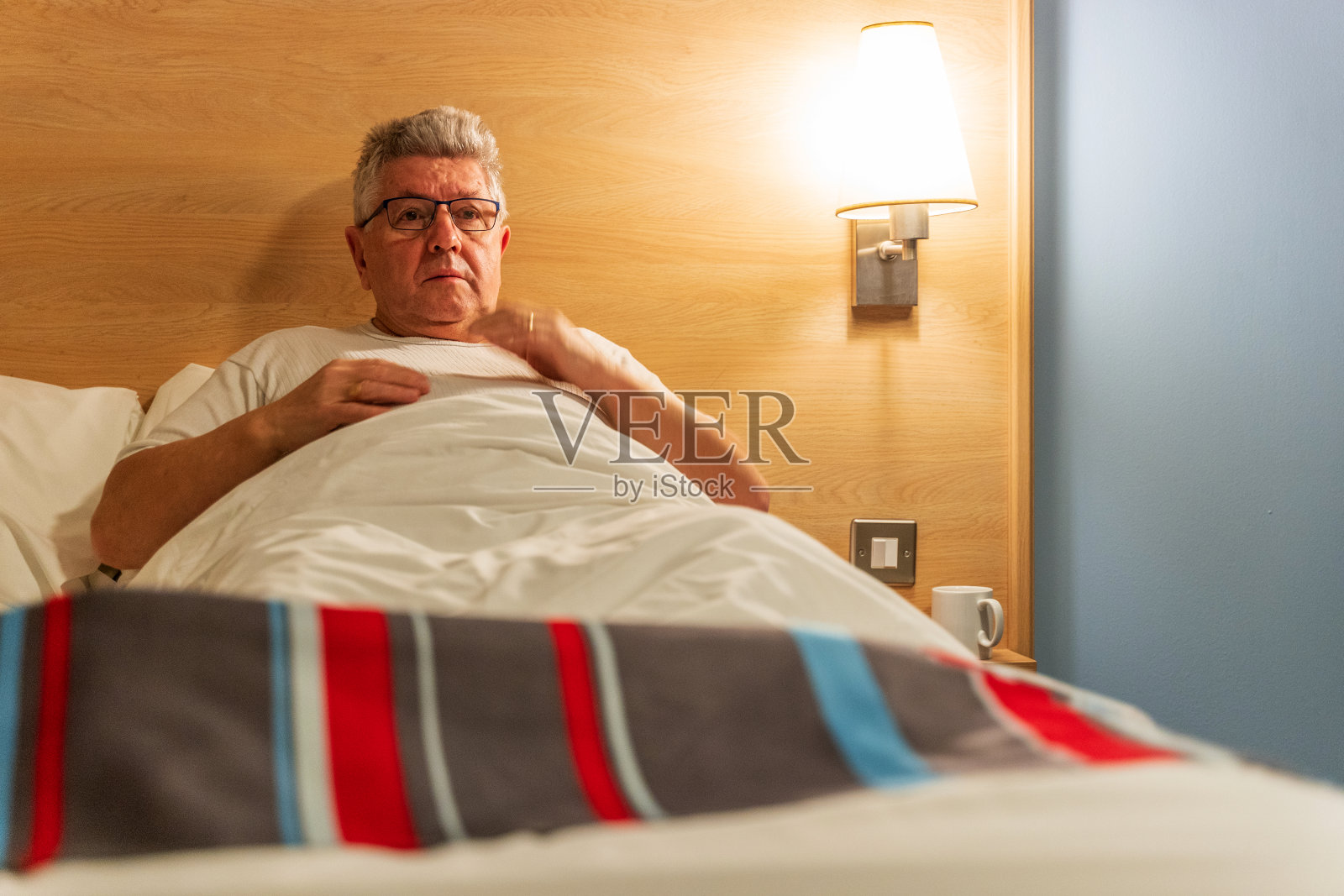 老人在床上看电视照片摄影图片