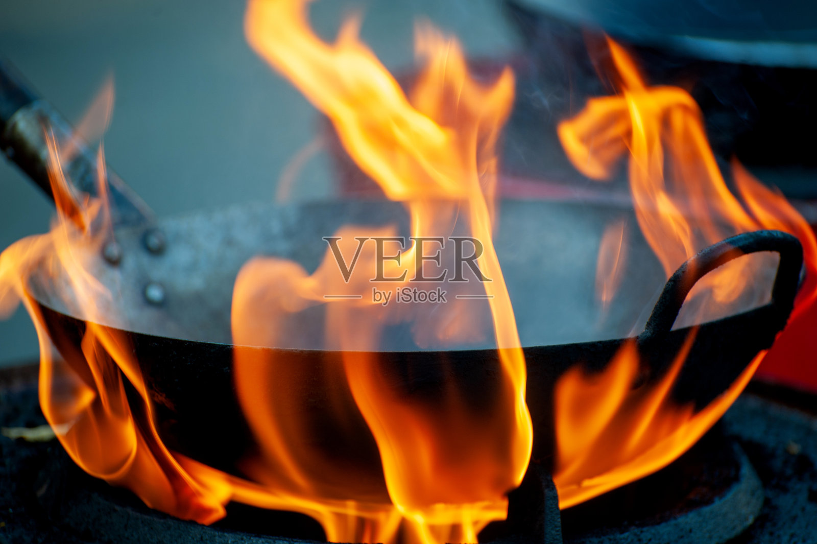 厨师在煎锅里用火烹饪照片摄影图片