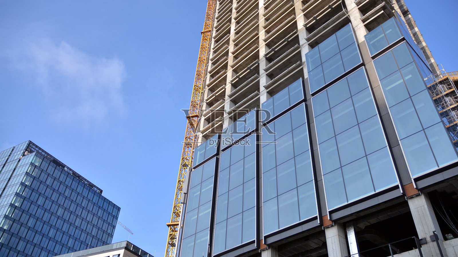 阳光明媚的下午，正在施工的摩天大楼。照片摄影图片