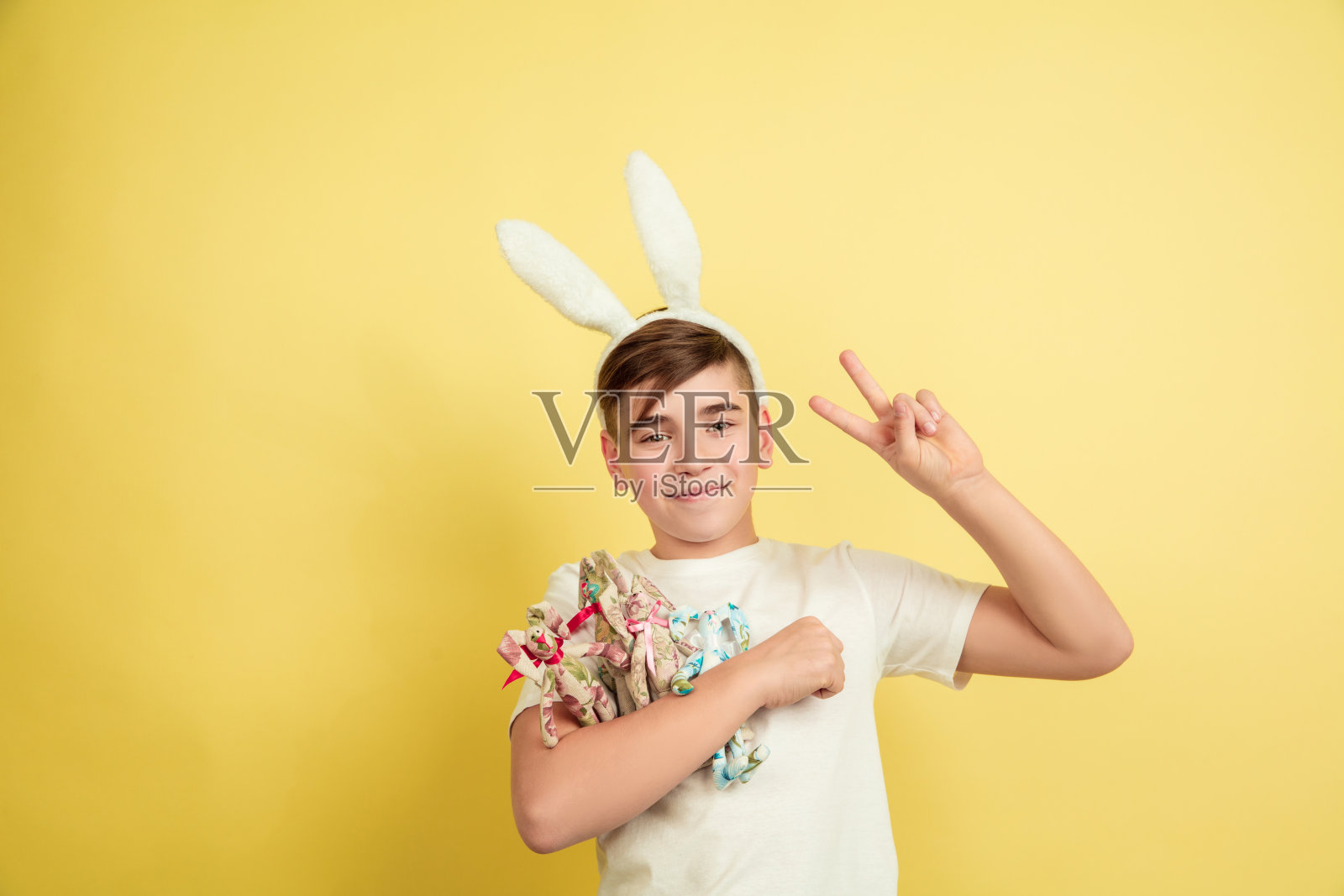 黄色背景上的复活节兔子男孩照片摄影图片
