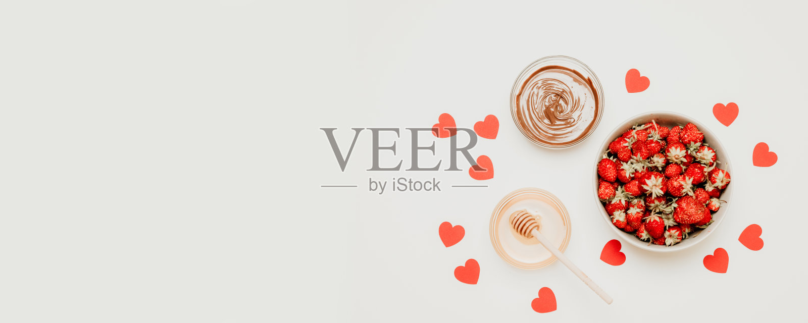 草莓，蜂蜜和巧克力酱在一个明亮的背景照片摄影图片