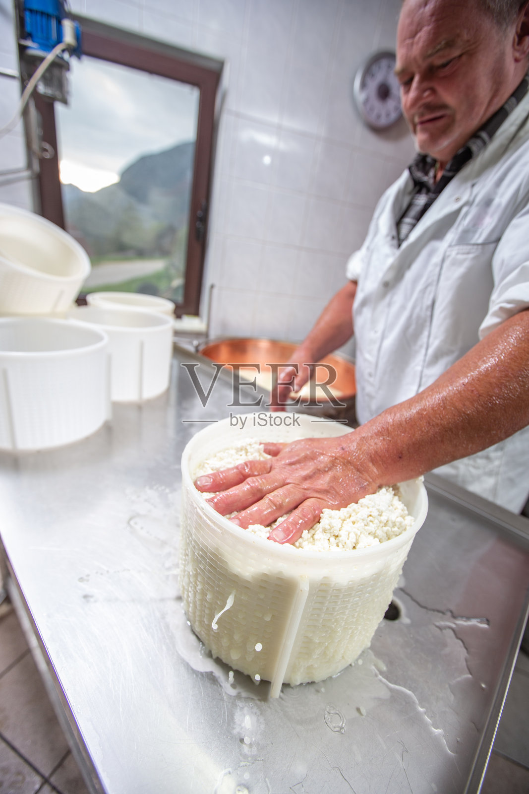 将凝乳放入塑料容器的农场工人照片摄影图片