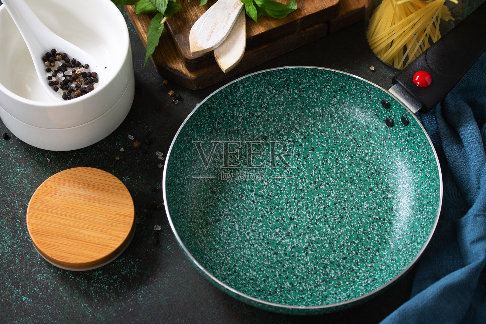 新平底锅与陶瓷涂层的石材厨房桌子周围的意大利菜配料。照片摄影图片