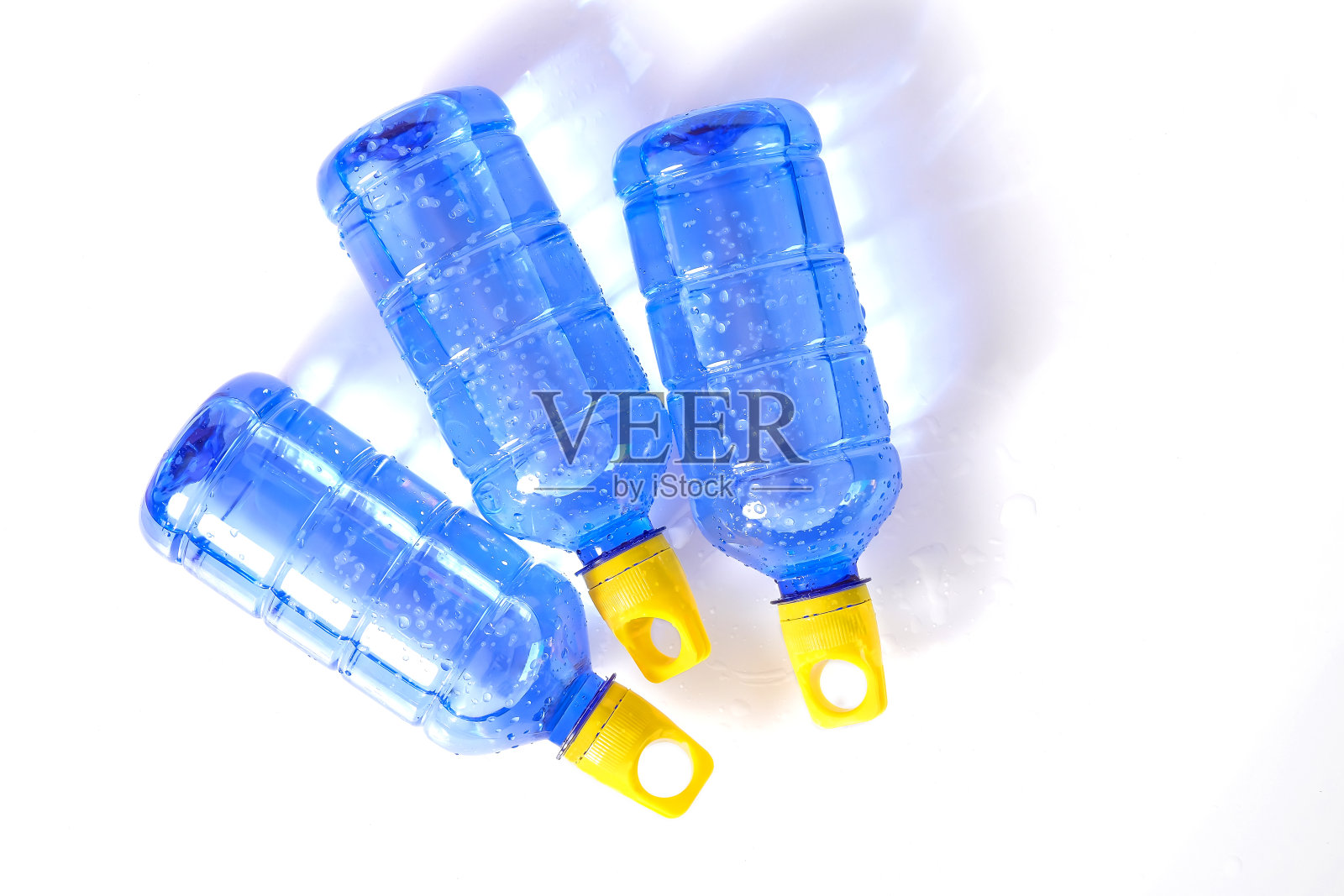 蓝色的水瓶，黄色的盖子，用来固定背景。照片摄影图片