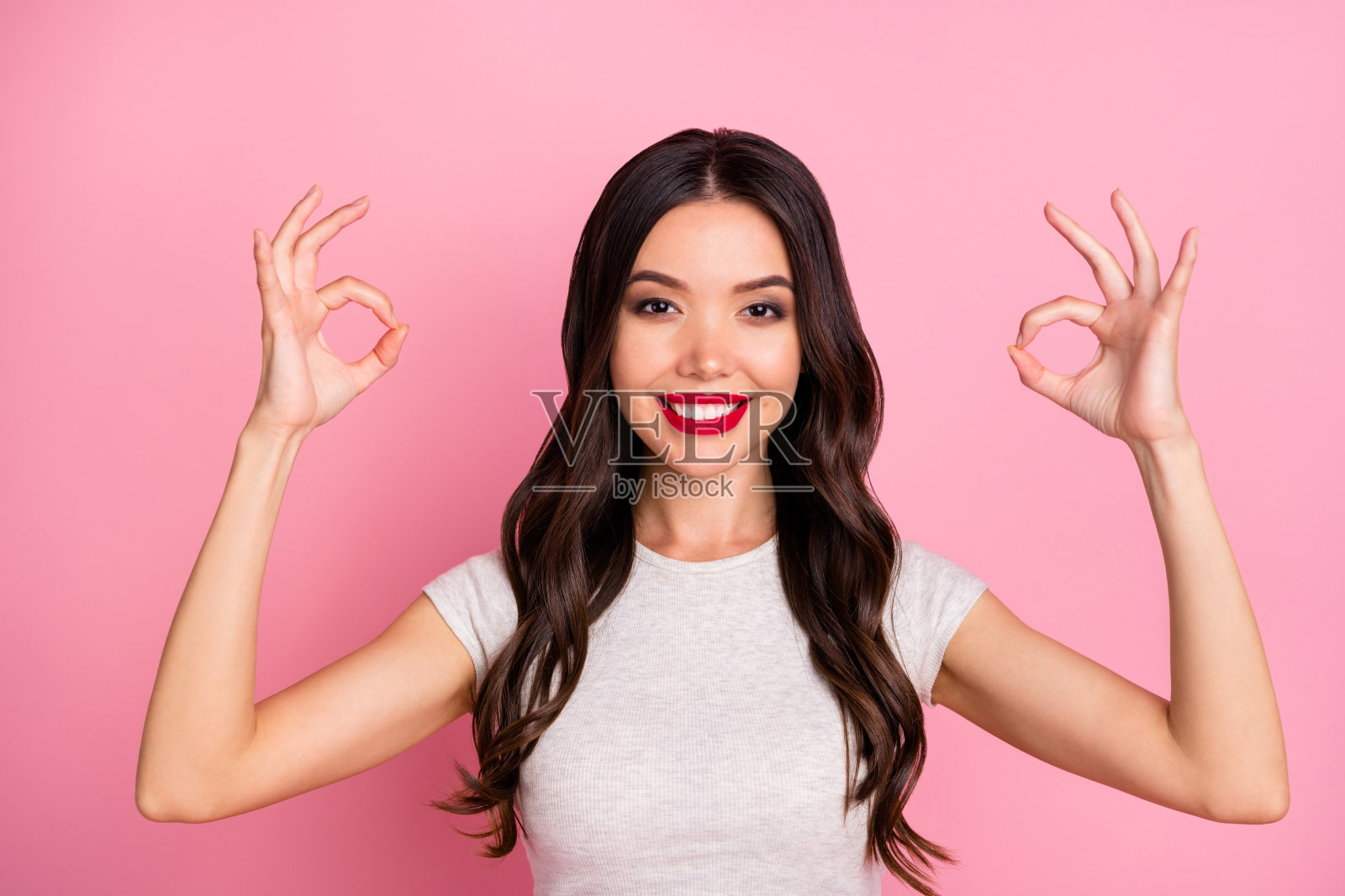 她的特写肖像，她好看的，有吸引力的，迷人的，可爱的，华丽的，愉快的，愉快的波浪头发的女孩显示ok标志孤立在粉红色柔和的颜色背景照片摄影图片