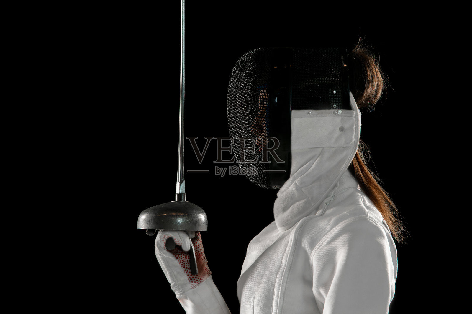 十几岁的女孩在击剑服装与手剑孤立在黑色背景照片摄影图片