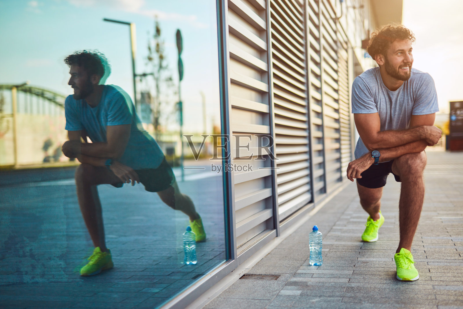 年轻人在市区做运动/伸展运动。照片摄影图片