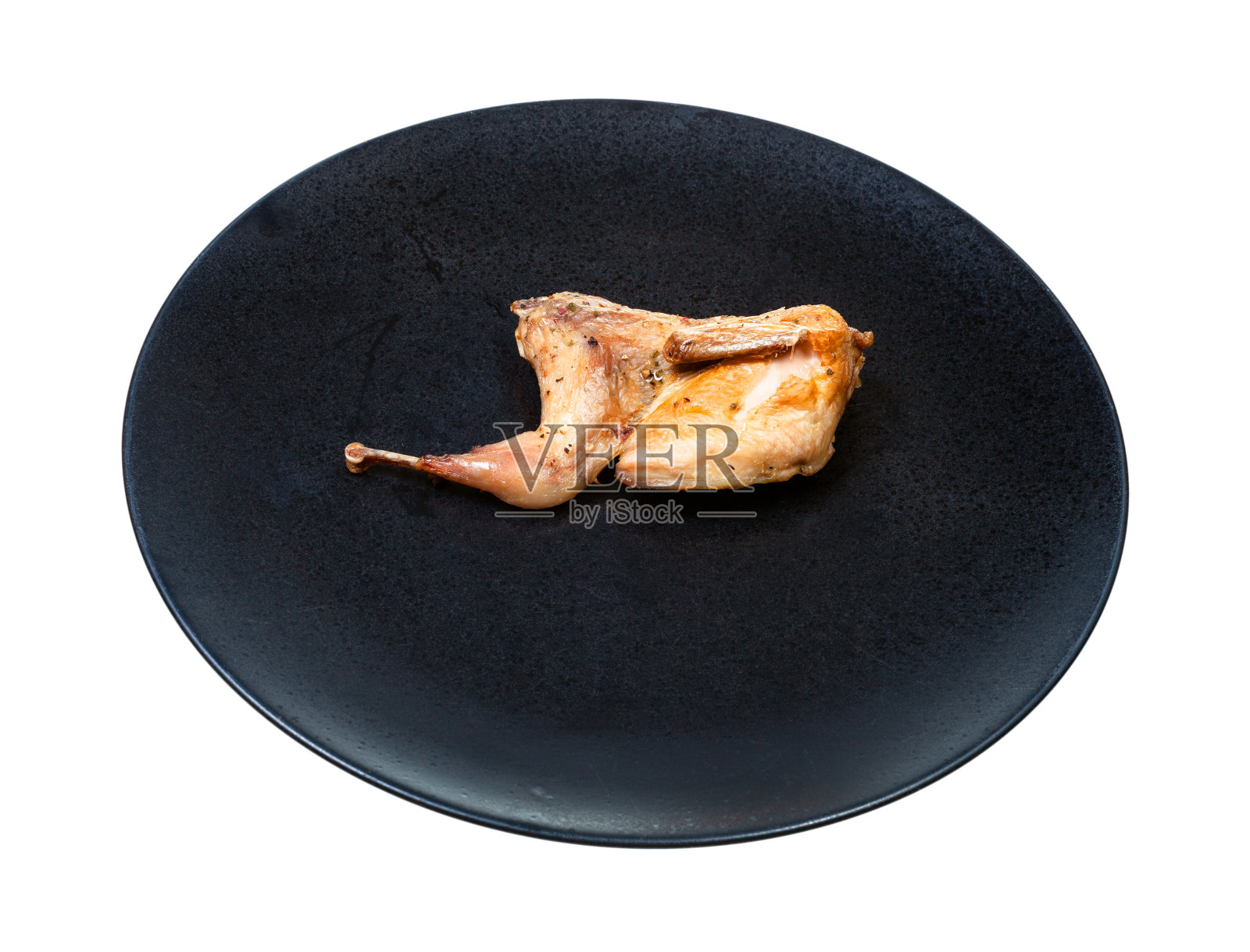 半只油炸鹌鹑单独放在黑色盘子上照片摄影图片