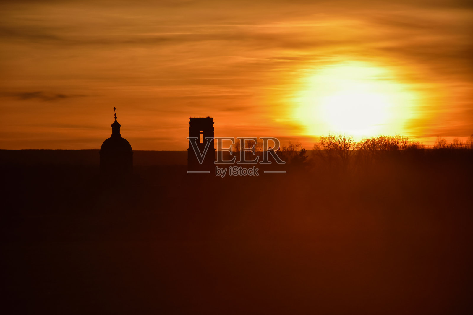 教堂的剪影在夕阳的背景，一个废弃的教堂在田野日落，教堂在彩色的日落天空，一个废弃的教堂在田野照片摄影图片