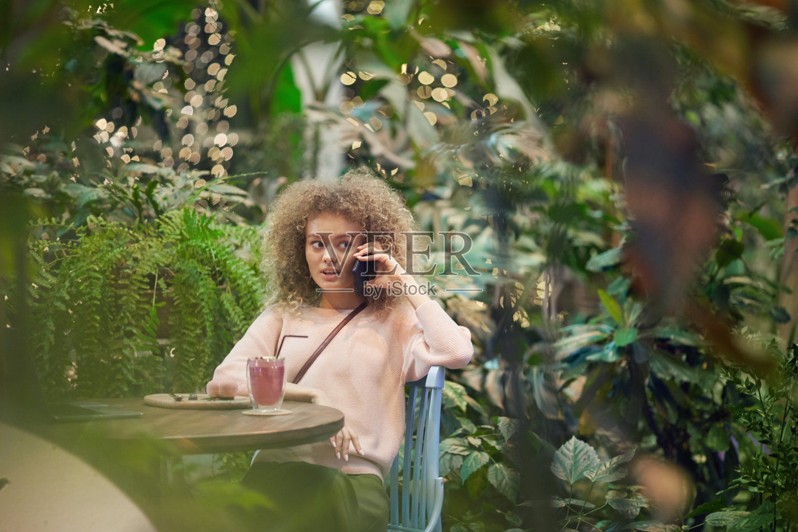 坐在咖啡馆里的漂亮女孩照片摄影图片