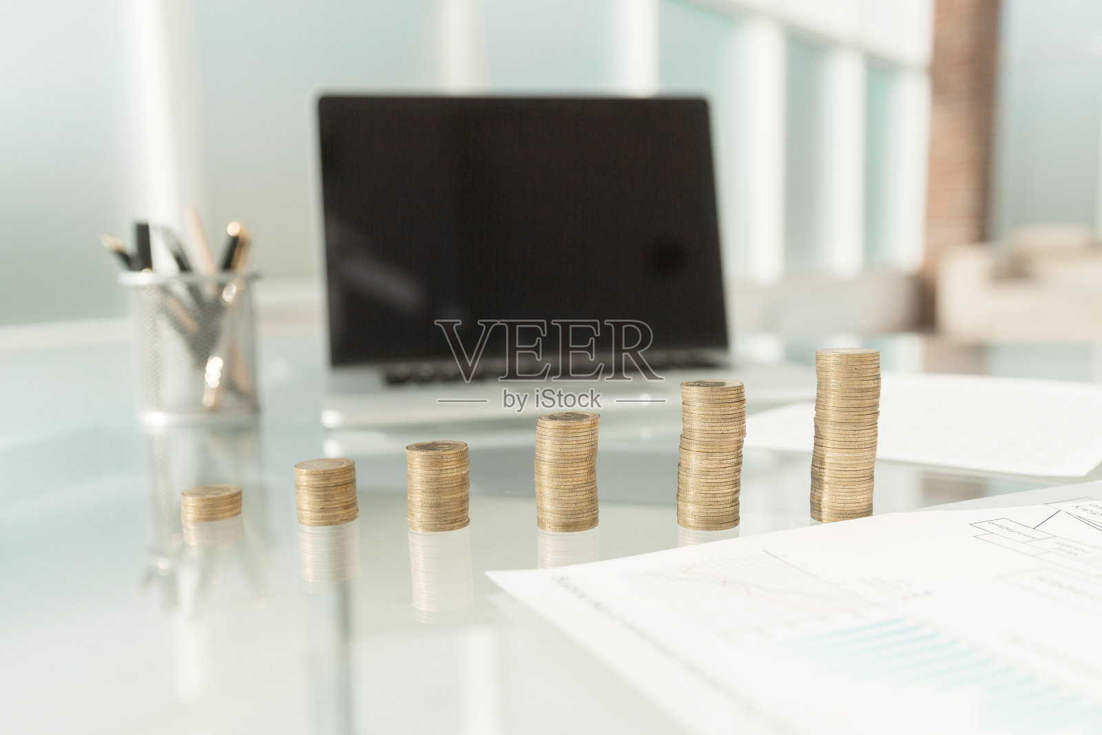 文件和成堆的硬币放在办公桌上照片摄影图片