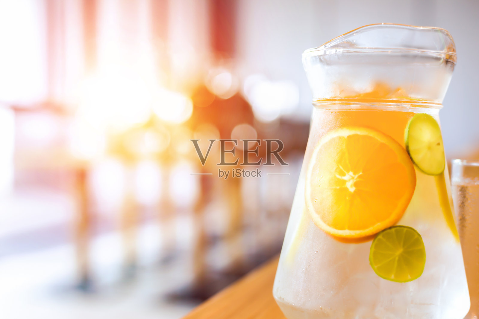 水里的水果和冰在桌子上。玻璃瓶里的水。用手和纸巾擦桌子。照片摄影图片