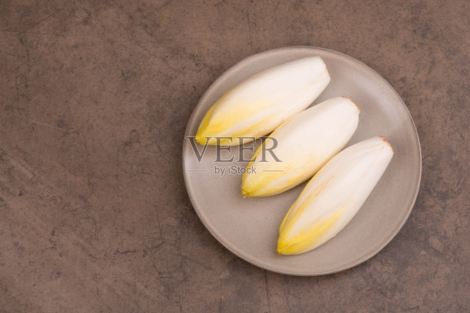 菊苣沙拉在棕色纹理的背景，空拷贝空间照片摄影图片