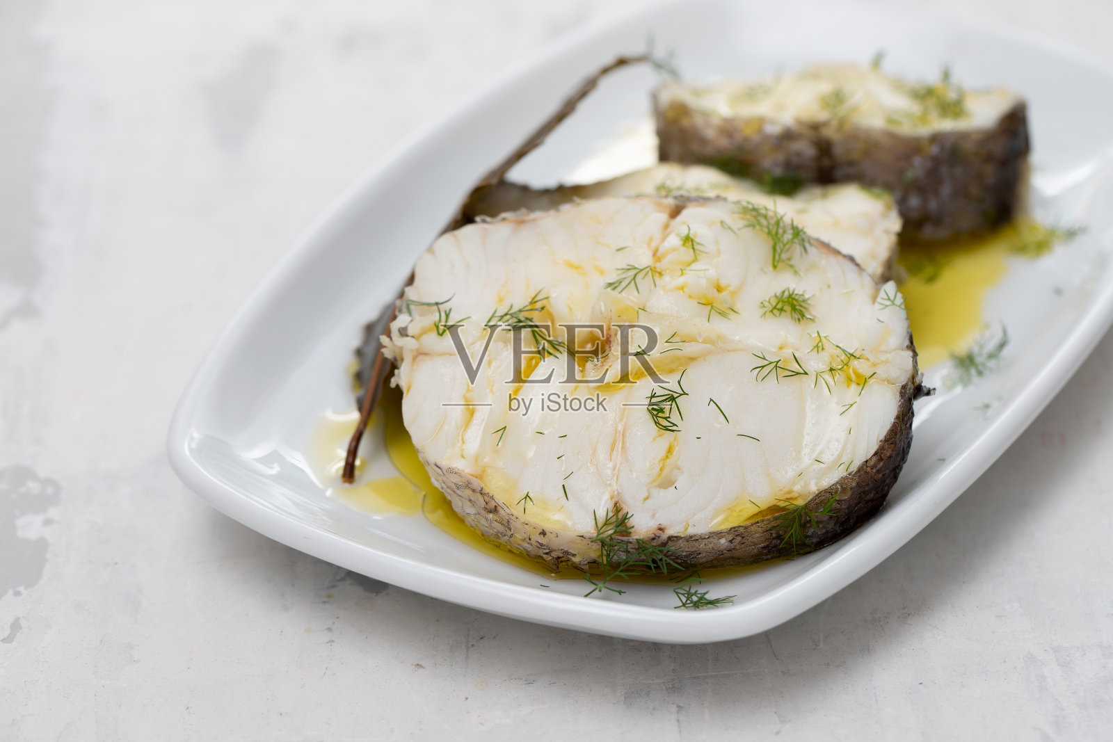 用橄榄油和月桂叶煮鱼照片摄影图片