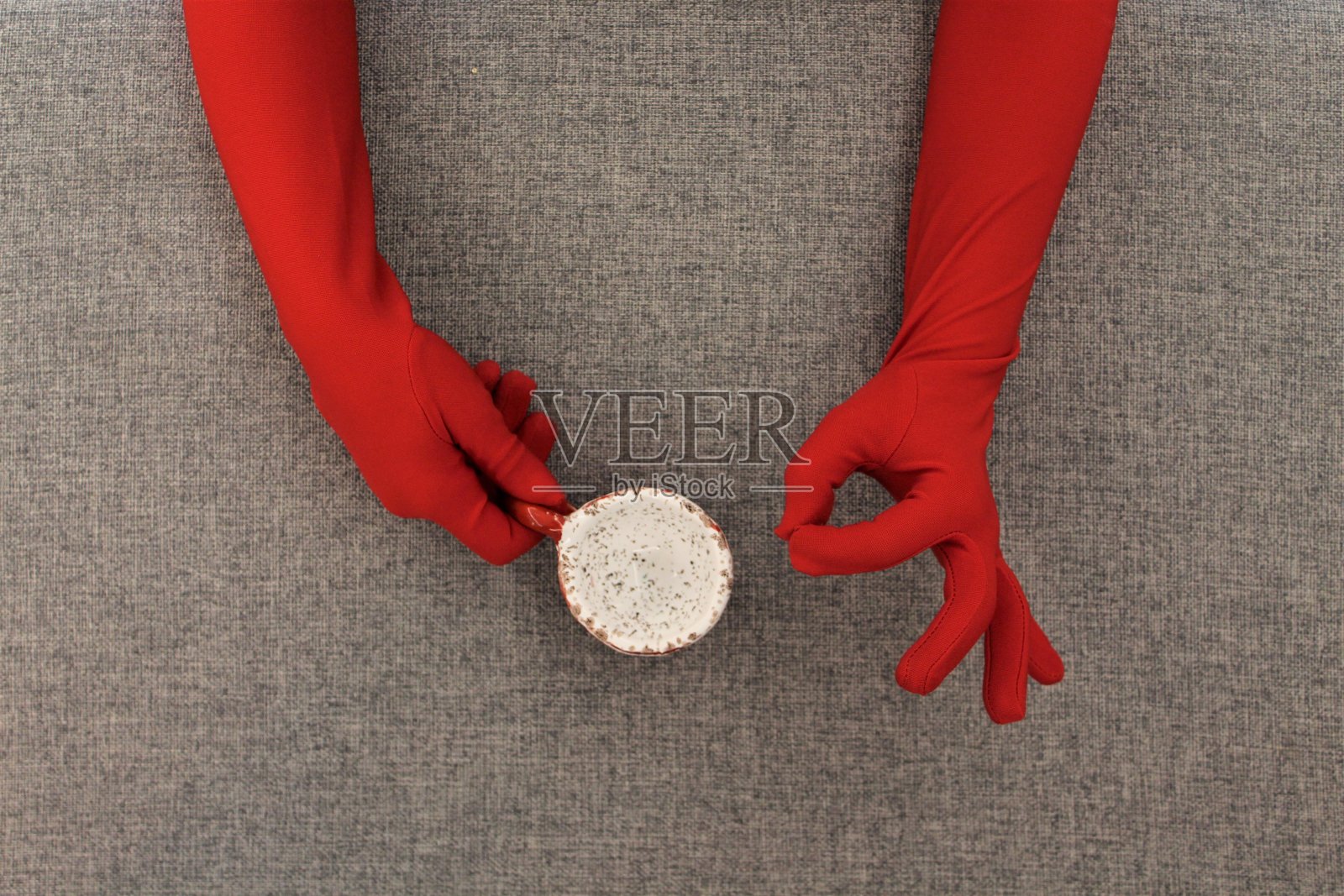 红色的手套手和一个咖啡杯照片摄影图片