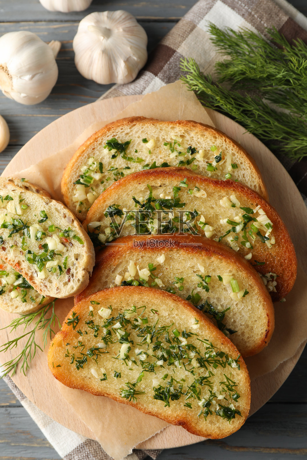 用烤蒜蓉面包和莳萝放在木板上，俯视图照片摄影图片