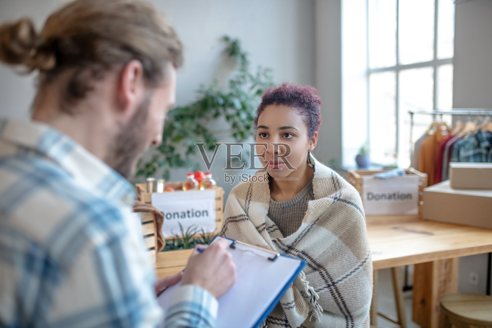 穿着格子衣服的年轻女孩看着对面的男人照片摄影图片