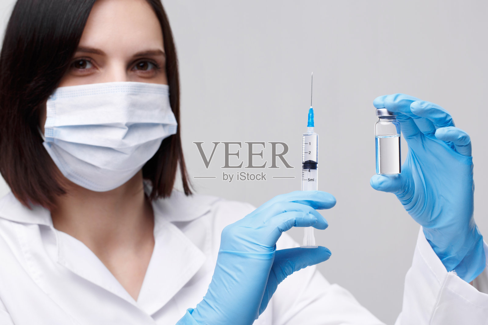 医疗注射、疾病、保健、科学、糖尿病。医院里的医生或护士拿着装有液体疫苗的注射器，准备进行注射。医疗设备。穿着白色制服、长袍的人们照片摄影图片