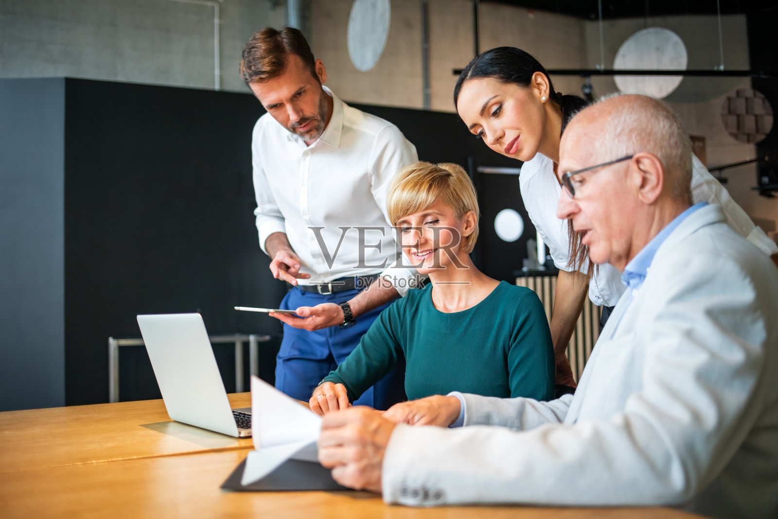在咖啡馆看笔记本电脑并讨论的商务人士照片摄影图片