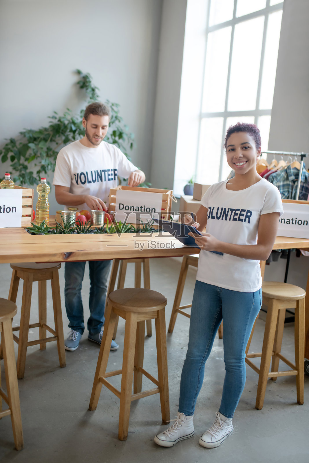 年轻女孩和男人在社会中心做慈善工作照片摄影图片