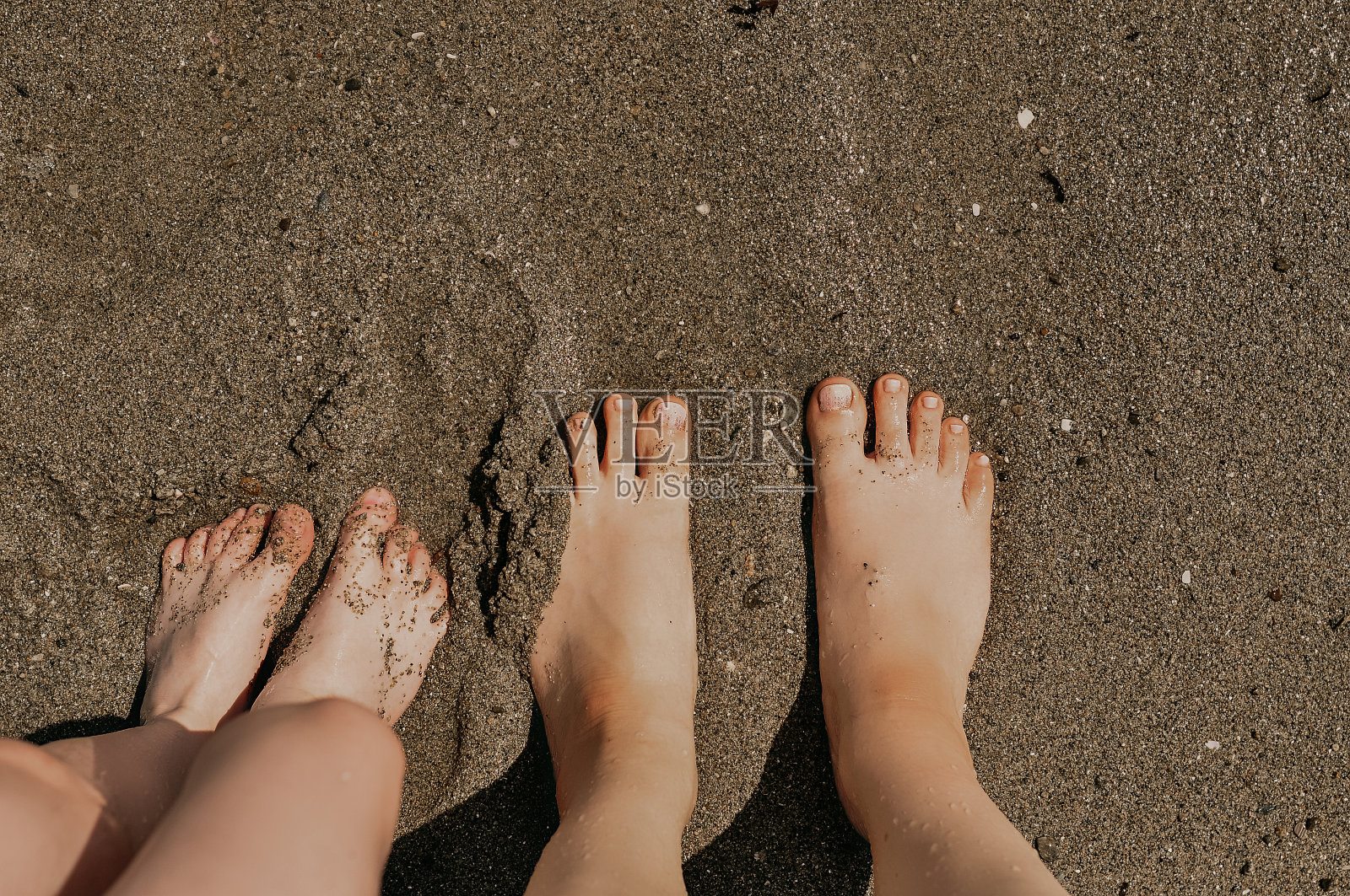 夏日海滩：成年女人和孩子的腿照片摄影图片