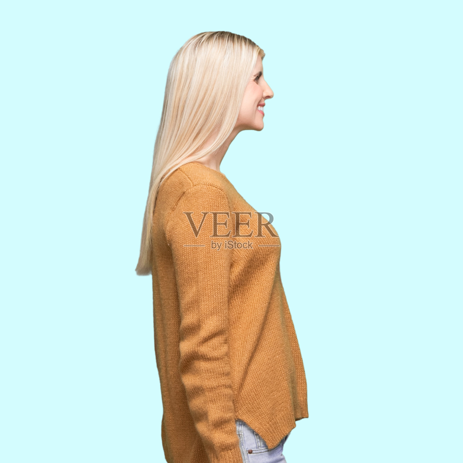 白人年轻妇女在有色背景前穿着暖和的衣服照片摄影图片