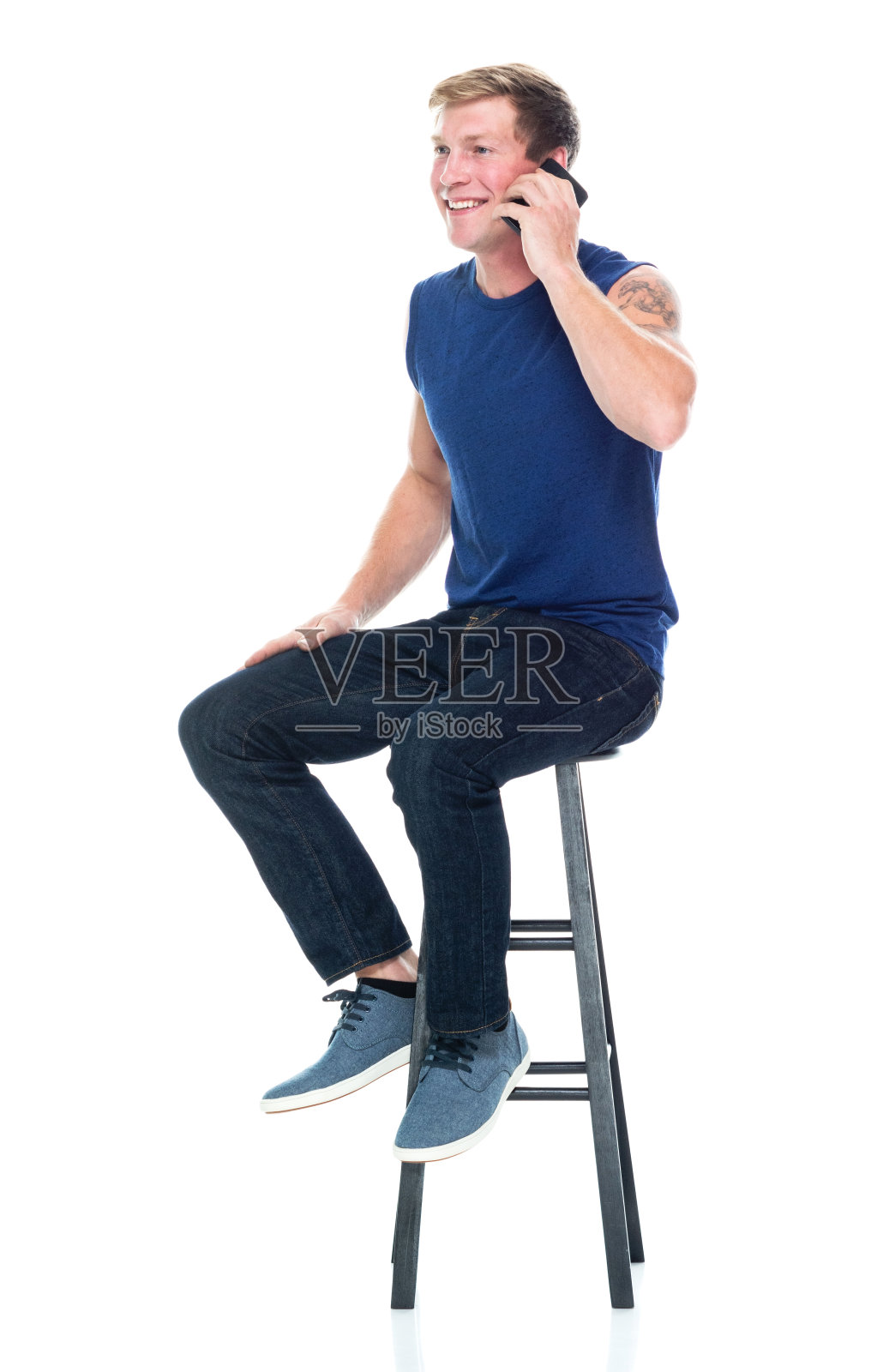 白人男性无袖坐着穿背心和使用智能手机照片摄影图片