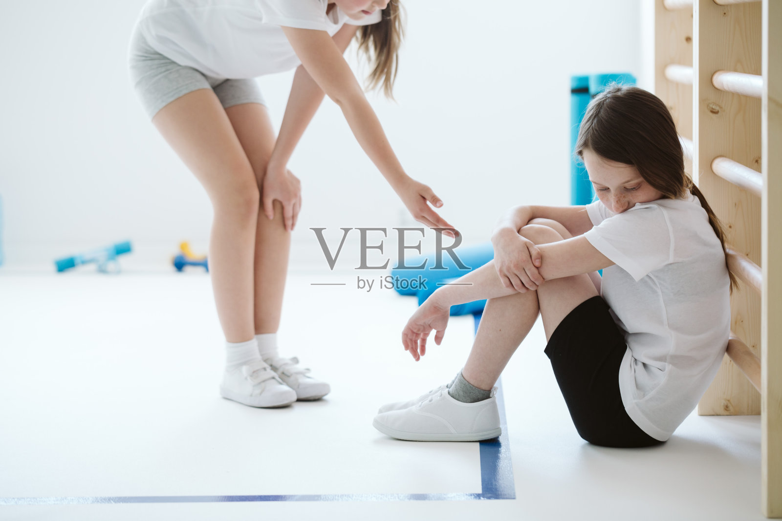 在健身房里向悲伤的朋友伸出援手的女学生照片摄影图片