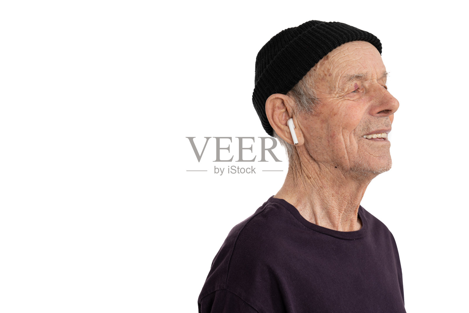 戴黑色帽子和白色无线耳机的时尚老人侧面肖像特写，白色背景，留白照片摄影图片