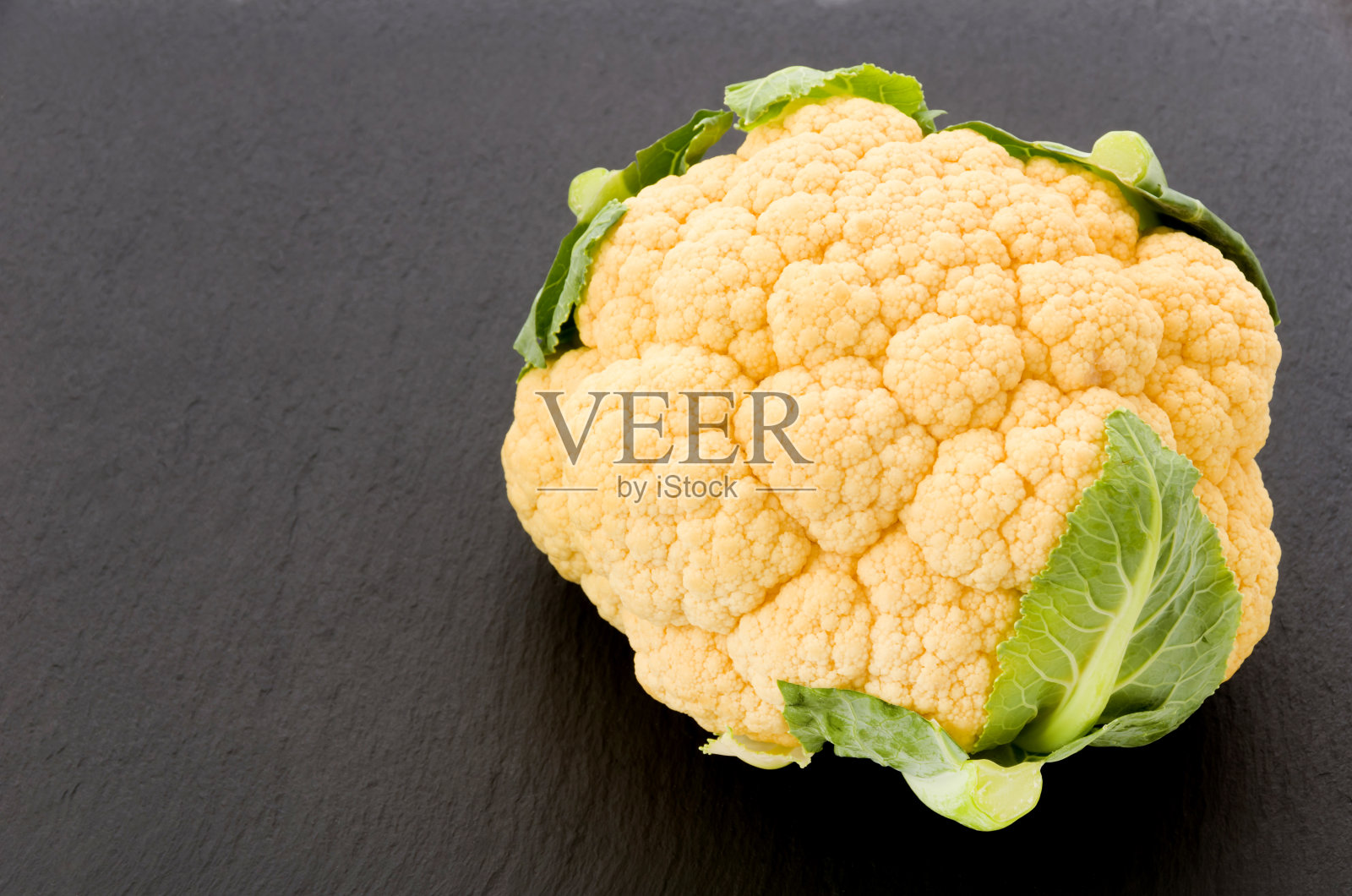 黑色石盘上的橙色花椰菜照片摄影图片