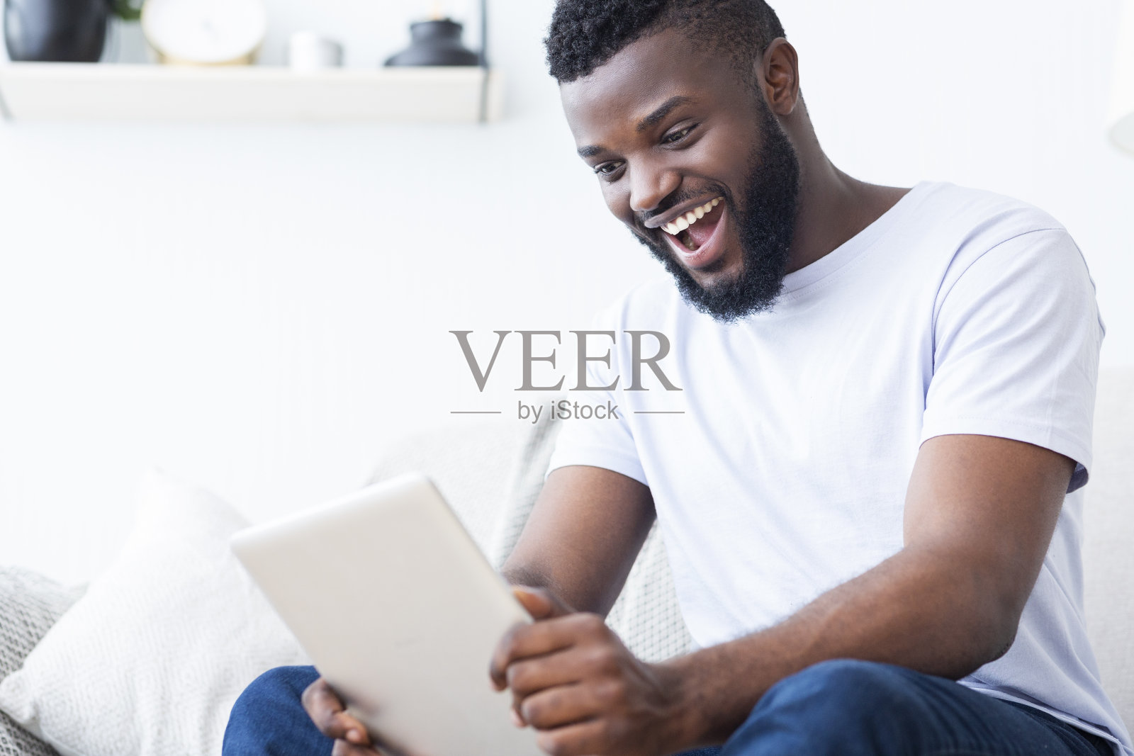 在平板电脑上看体育赛事的非洲球迷照片摄影图片