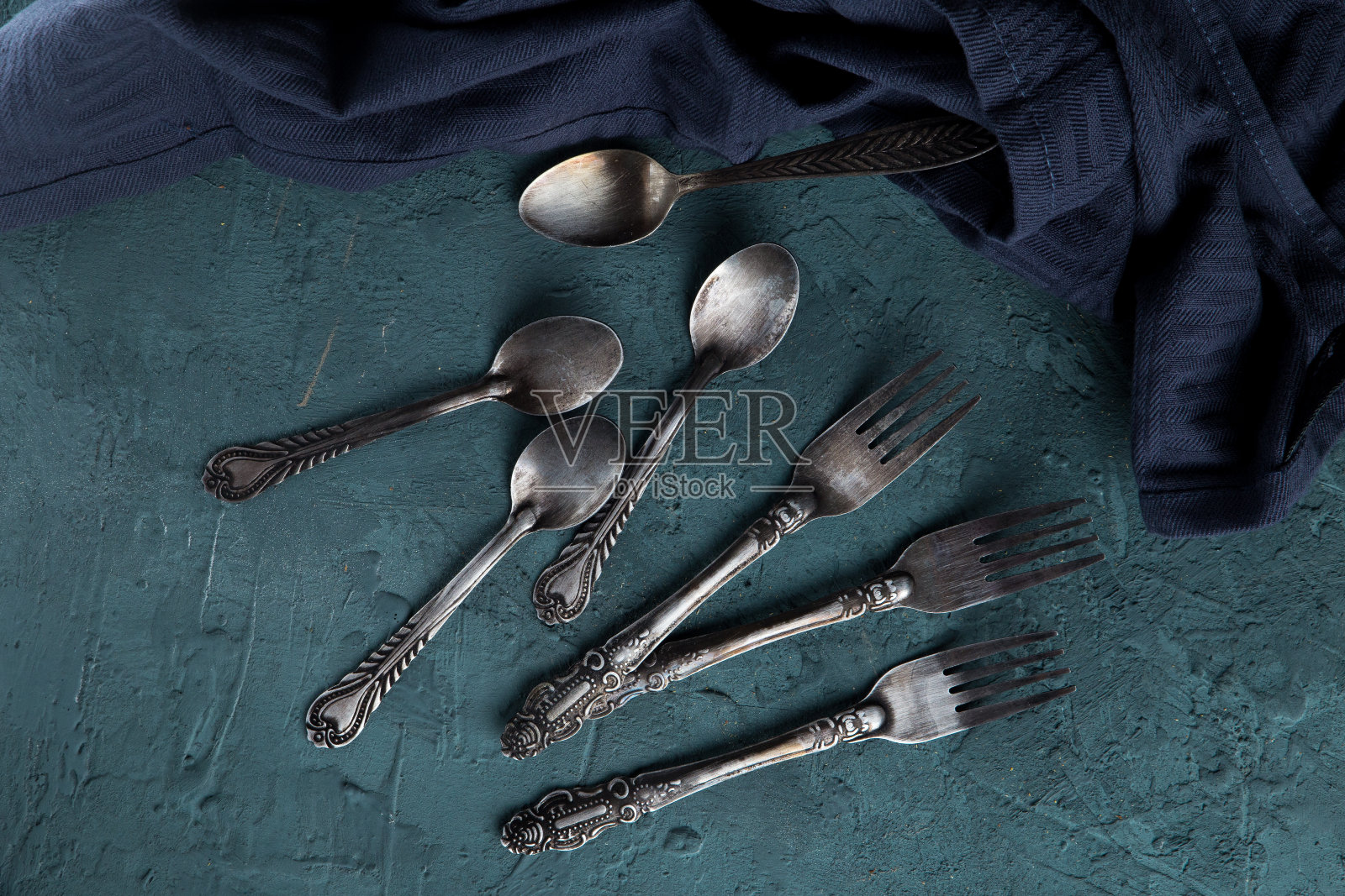 深色布旁边的复古古董乡村风叉子和勺子俯视图照片摄影图片