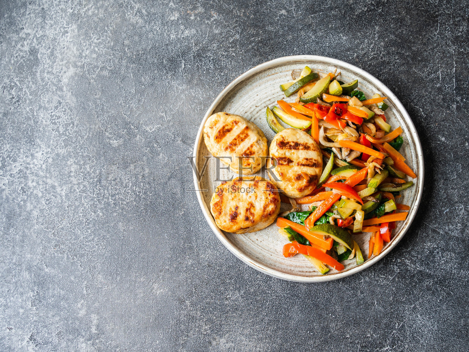 烤火鸡排，蔬菜steer fry在盘子上的桌子上的深色背景。俯视图照片摄影图片