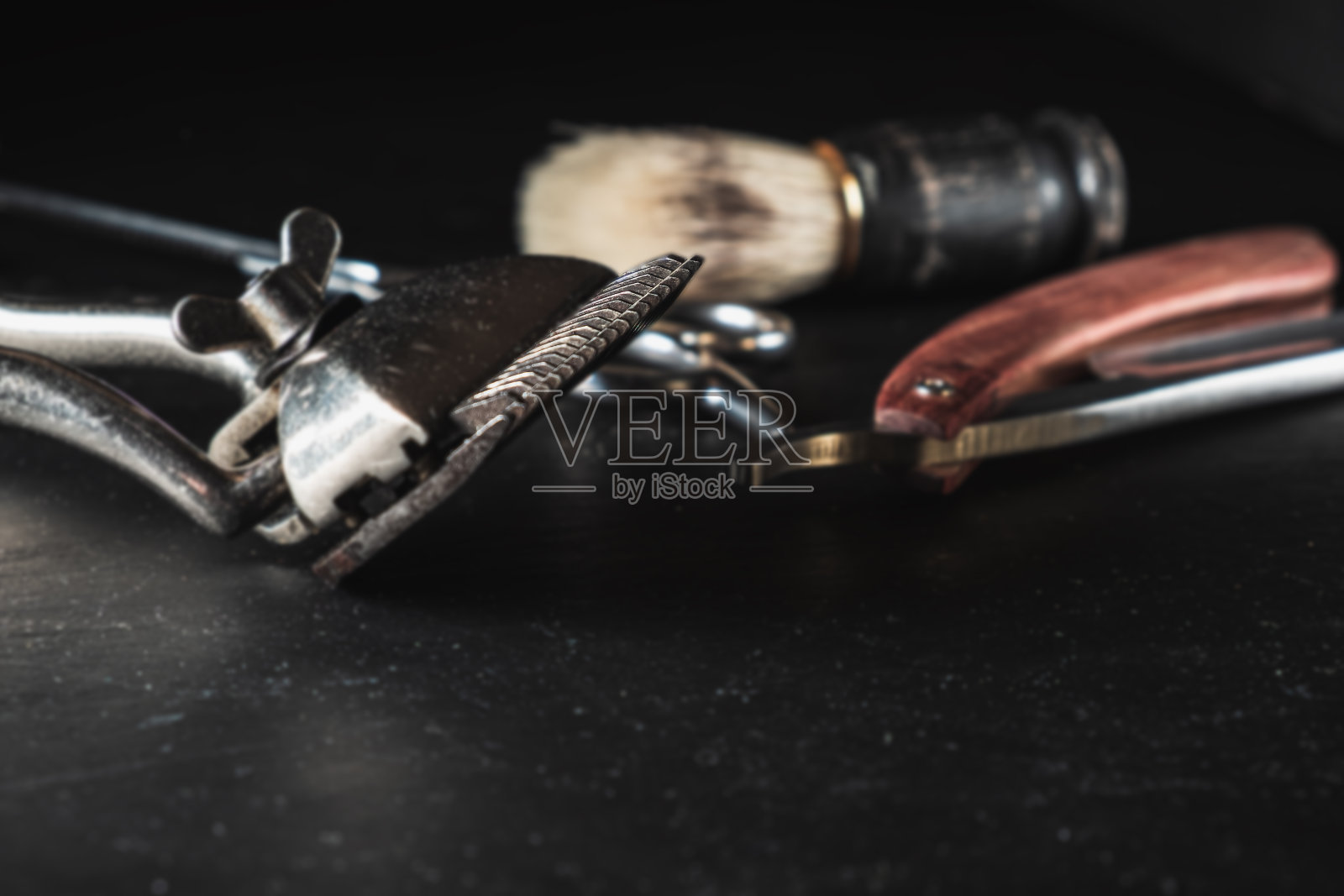 黑色背景上的老式理发店设备。专业美发工具。剪刀，手动理发器，剃须刀，剃须刷。本空间照片摄影图片