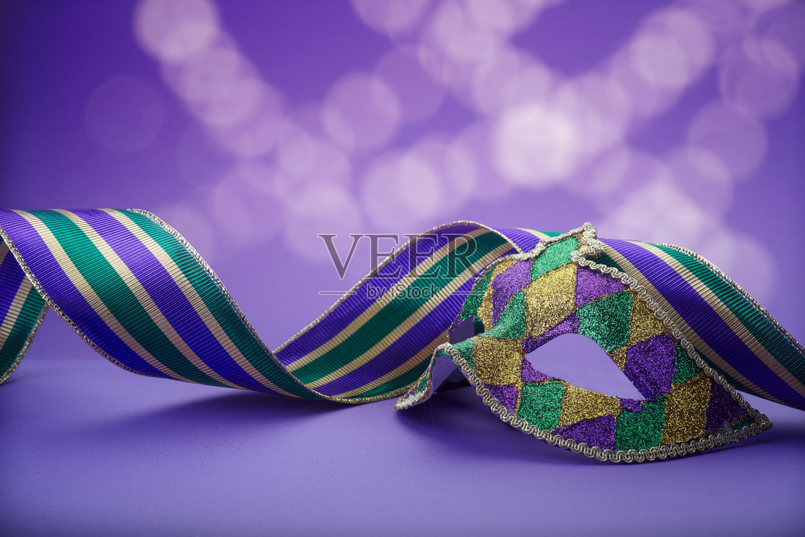 桌子上放着传统的狂欢节面具。背景是闪闪发光的面具。四旬斋前的最后一照片摄影图片