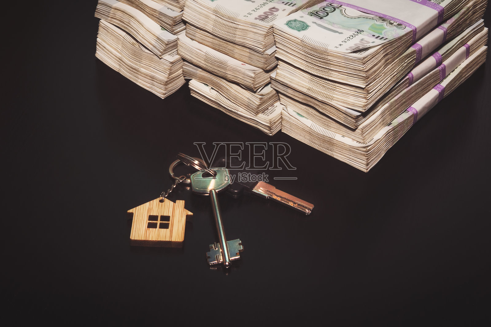 黑色桌子上放着俄罗斯卢布和公寓钥匙。房地产销售。出售公寓的交易。的概念。照片摄影图片