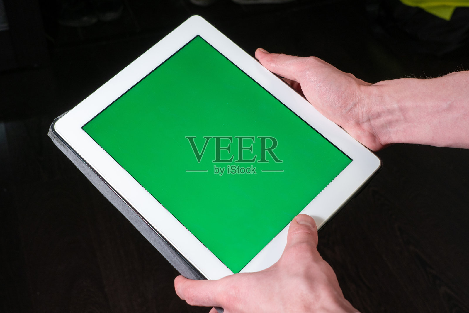 手持带绿屏的平板电脑照片摄影图片