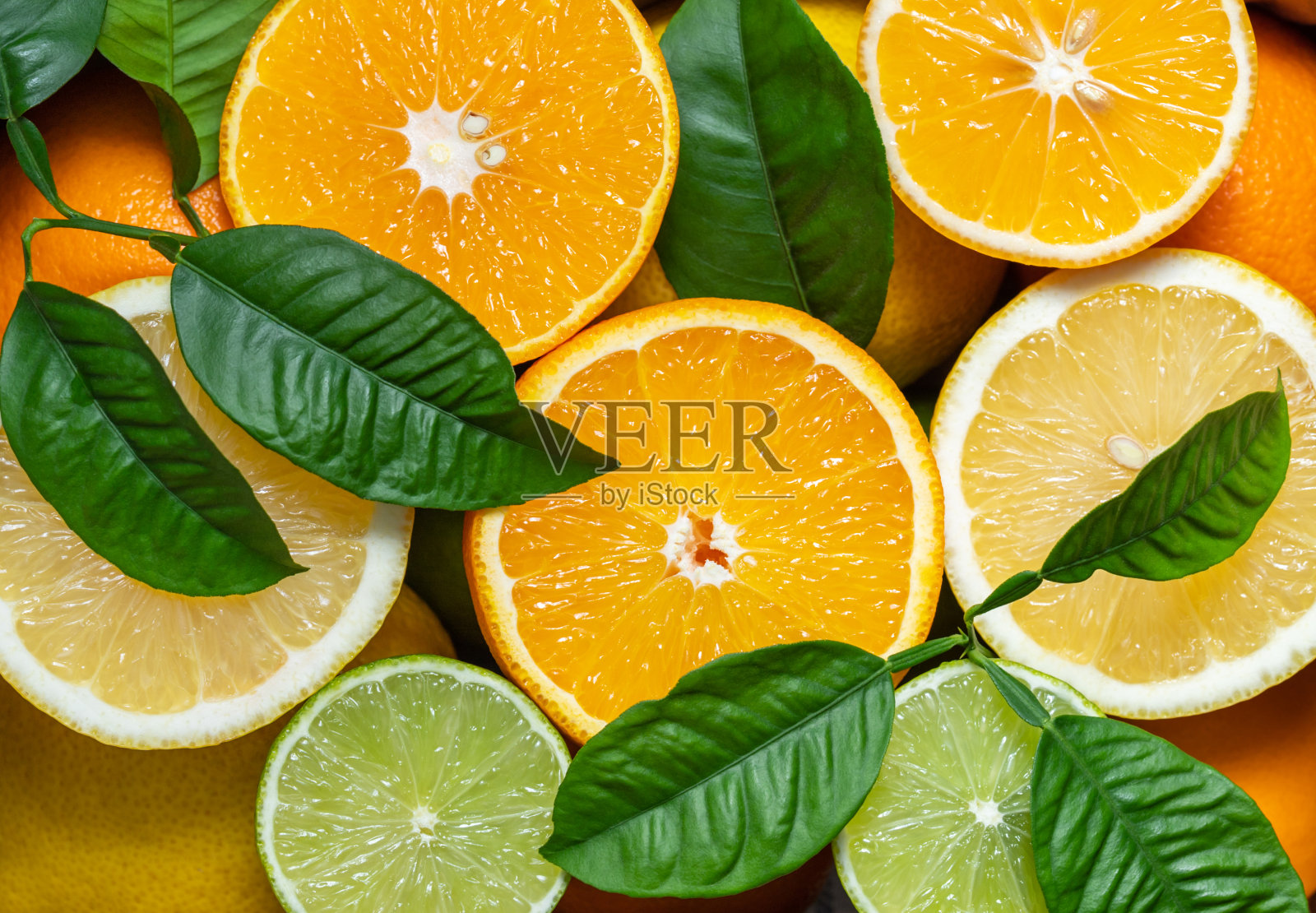 水果的背景。切片橙子，柠檬和酸橙特写。食品的背景。新鲜成熟的水果混合物。水果图案和质地。照片摄影图片
