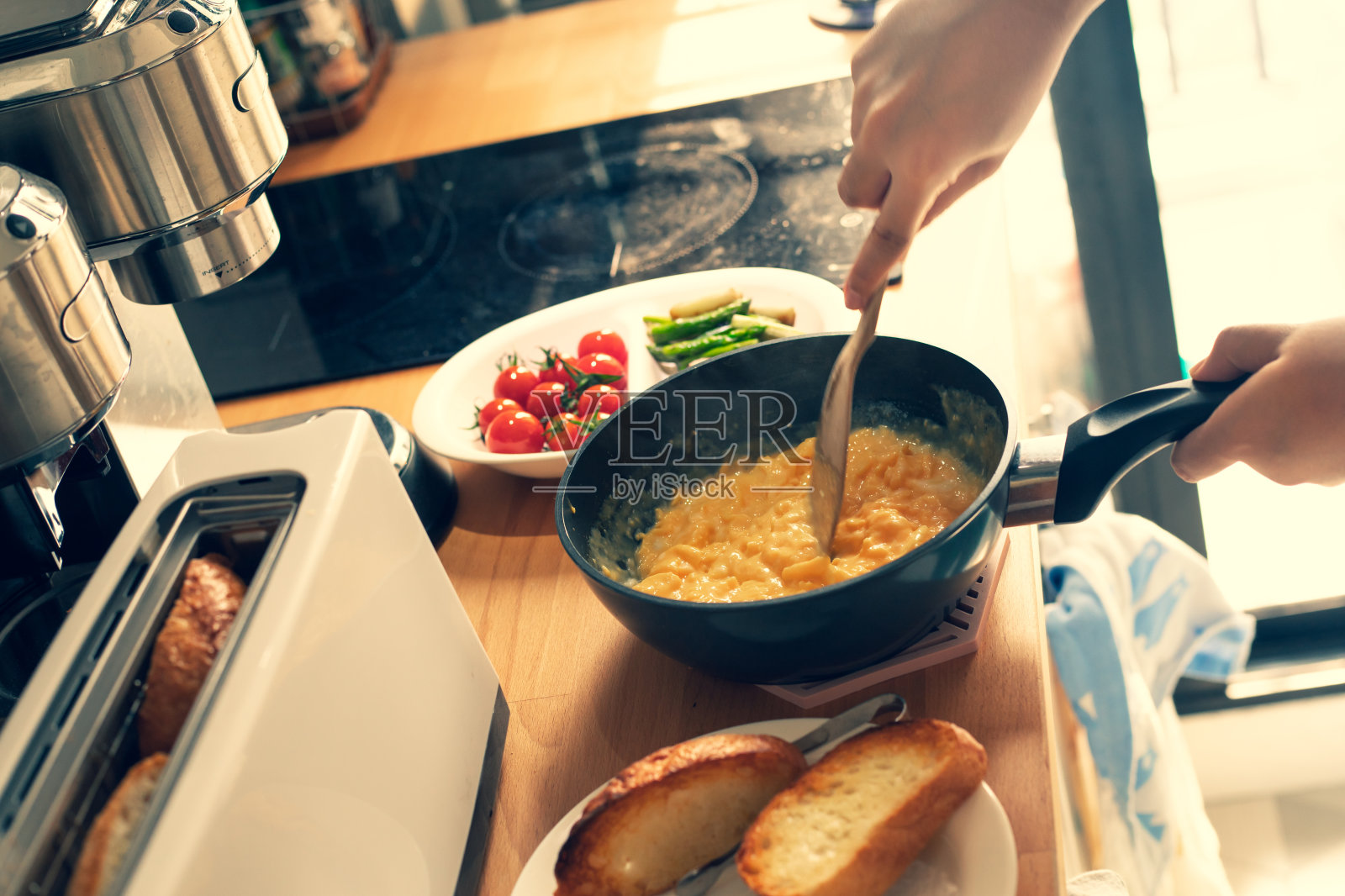 女性早上在厨房吧台做早餐的选择性重点照片摄影图片