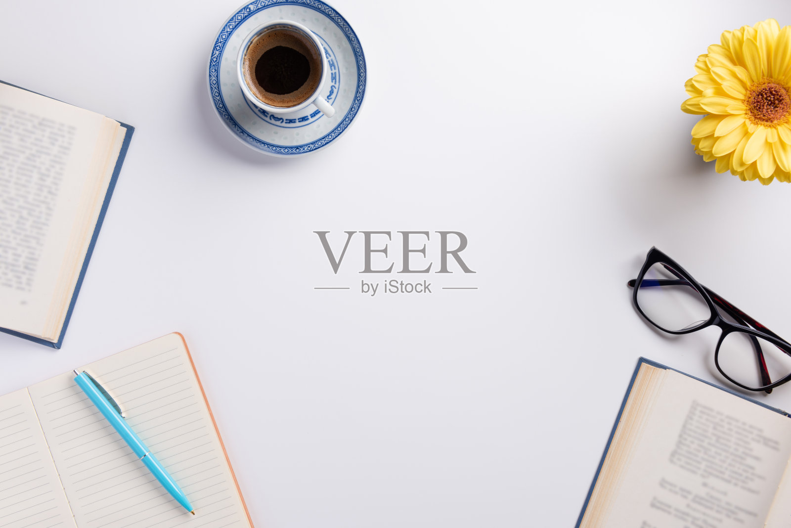 工作场所可以打开书，喝杯咖啡。一杯咖啡，一朵花，一本笔记本，孤立在白色的背景上。平铺，俯视图，拷贝空间。照片摄影图片