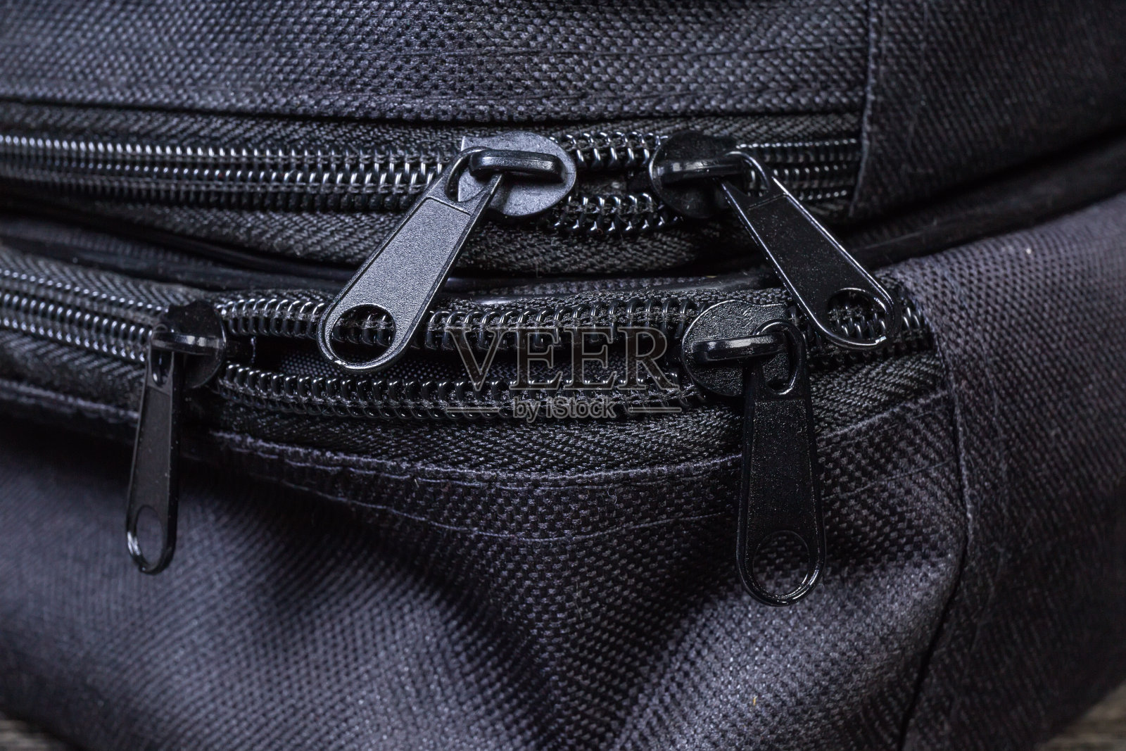 金属滑块上的塑料拉链上的黑色袋子特写照片摄影图片