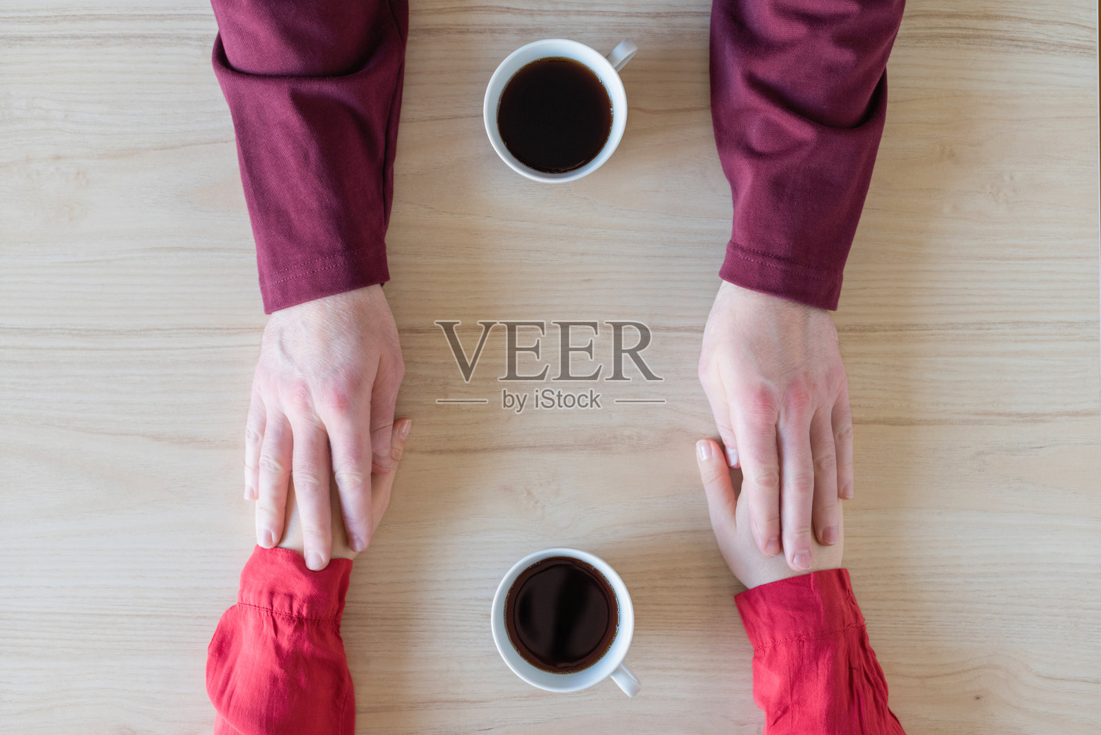 女人和男人坐在咖啡馆的桌子旁，手牵着手。爱情,浪漫,日期照片摄影图片