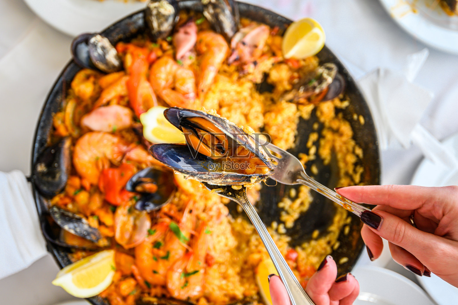 西班牙的海鲜饭，用平底锅盛海鲜。鲜虾、小虾、贻贝、鱿鱼、章鱼及扇贝。前视图。有选择性的重点。餐厅照片摄影图片
