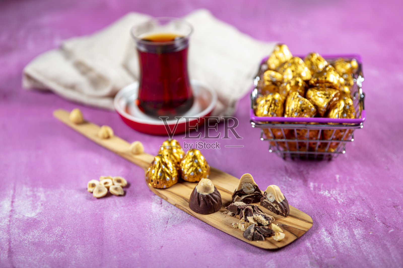 榛子巧克力用金箔纸包裹，以莱拉木为背景。开斋节(斋月盛宴)的概念。照片摄影图片