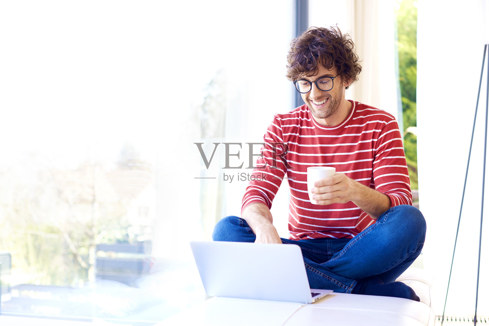 在家放松时使用笔记本电脑的快乐年轻人照片摄影图片